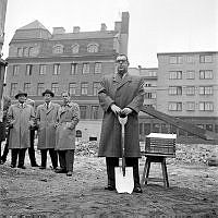 Borgarrådet Gösta Wennerström tar första spadtaget för blivande ABF-huset. Bredvid honom en liten modell av det blivande studiehemmet. Till vänster Adolf Fredriks församlingshus på Kammakargatan 30.