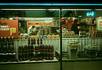 Skyltfönster till livsmedelsaffär vid Hötorgets tunnelbanestation med expedit och kund i affären.
