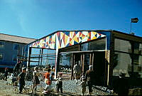 Vällingby. Konsumbutik med glasade fasader och gavelutsmyckning på sydfasaden i raka nonfigurativa mönster i färgerna gult, rött, blått och vitt.