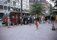 Humlegårdsgatan vid hotell Anglais. Spårvagn på Lidingöbanan, linje 20. Väntande människor vid hållplats Humlegårdsgatan.
