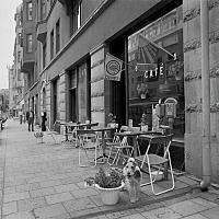 Trottoarvy söderut med café i förgrunden från Gästrikegatan 13 