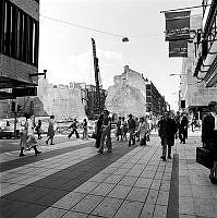 Drottninggatan norrut från korsningen Mäster Samuelsgatan. Rivning av flera hus i kvarteret Blåmannen blottlägger brandgavlarna till gård- och gathus på Drottninggatan 53