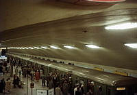 Tunnelbanetåg till Hökarängen som stannat på Odenplans T- banestation. På och avstigande människor. Överblick på perrong.