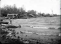 Strand och klippor. Båthus och bodar.