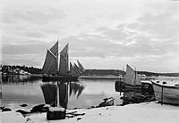 Segelfartyg i skärgårdsvik utanför ångbåtsbryggan.