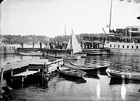 Ångbåten Norrtelje ligger vid ångbåtsbryggan. Myckket folk ombord och på bryggan.