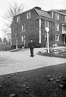 En man står på en grusväg utanför ett trähus, som inrymmer telegrafstationen.
