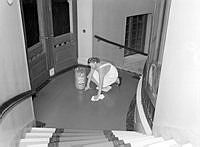 Södra Blasieholmshamnen 8. Kvinna i arbete med att torka golv i trapphus på Grand hotell. 