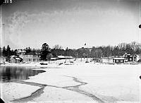 Vy mot land från isen. Telegrafhuset, Konditoriet,  Affären och Tullis. Lindholms hus med jordkällare och kvarn.