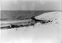 Snötäckt skärgårdsstrand. Nordkap.