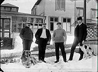 Fyra män och två hundar framför Restaurangens matsal. Mannen längst till höger är Inspektor Adolf Fredrik Freese. 