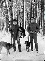 Knut Södergren och Hjalmar Doré med gevär, hundar och byte efter en rävjakt. 