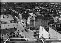 Hörnet Sveavägen och Kungsgatan. Vy från södra Kungstornet, längs Kungsgatan västerut. Spårvagnen svänger in till höger på Sveavägen. Till vänster Konserthuset.                                       