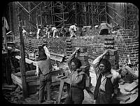 Tegelbärare och murare i arbete vid stadshusbygget i juli 1916.