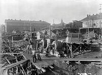 Cementarbetare i arbete vid betongblandare. Grund- och schaktningsarbeten vid Stadshusbygget.