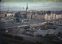 Vy över Gamla stan och Franska bukten med motorbåtar och bogserbåtar. I förgrunden spår och godsvagnar i Stadsgården.