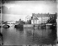 Helgeandsholmens nordvästra sida från Strömgatan. I bakgrunden Norrbro och Grand Hotel