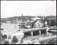 1897 års Allmänna konst- och industriutställning sedd från Strandvägen.
Närmast provisorisk bro till området och i bakgrunden Djurgårdsbron