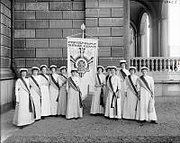 Deltagare vid den internationella kvinnliga rösträttskongressen i Stockholm år 1911 uppställda med standar vid Södra Blasieholmshamnen.