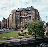 Kungsbroplan; liten park med blomformad plantering. Vy mot kv. Härolden, Kungsg. och Fleminggatan. I fonden bl.a. dansrestaurangen Kungsbrohof-