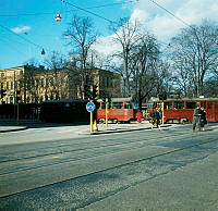 Ett tåg på Lidingöbanan svänger runt hörnet av Sturegatan och Humlegårdsgatan. I fonden Kungliga Biblioteket.