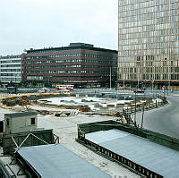 Anläggandet av fontänen vid Sergels Torg. Vy mot EPA och femte Hötorgshuset. Byggfutt i förgrunden.