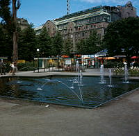 Kungsträdgården. Damm med små fontäner i parkens norra del. Turistbyrå i kv. Sju Sekel. Vy mot Nordiska Kompaniet.