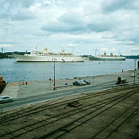 Passagerarfartygen Kungsholm och Nieuw Amsterdam (Holland) för ankar på Strömmen. Vy från Östra Slussgatan över Stadsgårdsleden.