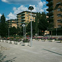 Blomsterurnor i Tessinparken vid T-banestationen Karlaplans norra uppgång. Vy åt nordost mot De Geersgatan.