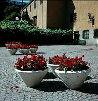 Blomsterurnor med röda begonior på gårdsplanen framför Historiska Museet. Vy åt söder.