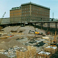 Grundarbeten i de utgrävda kvarteren Frigga och Skansen. Vy åt nordost mot Telegrafverket i kv. Fyrmörsaren. Beridarbansgatan på stolpar.