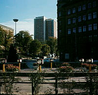 Trafikfri rondelliknande plats vid Ingemarsgatan 1 omgärdad av parksoffor. Låga trafik-/parkljus och blomsterurnor. Vy åt öster.