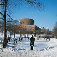 Observatorielunden; några pojkar spelar ishockey på plaskdammens is. Vy mot Stadsbiblioteket.