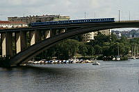 Tranebergsbron sedd mot Fredhäll. Utsikt från Svartviksslingan 79, Minneberg. Tunnelbanetåg passerar över bron.