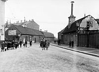 Brännkyrkagatan vid Hornskroken. Ett tjugotal barn har samlats. Skylt på byggnaden till vänster: 