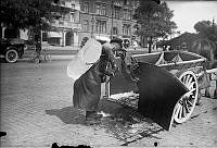 Iskarl med isblock på ryggen vid sin häst och vagn på Strandvägen.