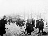 Spårvagnskonduktörer skottar bort snö från spåret på Strandvägen.