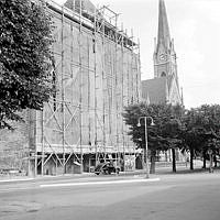 Narvavägen 8 bakom byggnadsställningar. T.h. Oscars kyrka.