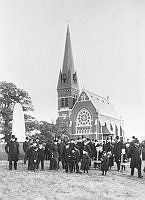 Gustav Adolfs kyrkan sedd med folksamling i förgrunden.