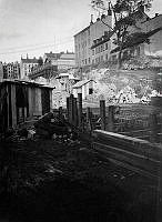 Anläggningsarbete vid Kungsgatans framdragande. Lutternsgatan sprängdes och urschaktades genom Brunkebergsåsen 1905-1911. T.h. Lutternsgatan 12 A och B i kv. Kåkenhusen, nu Kungsgatan 8-10.