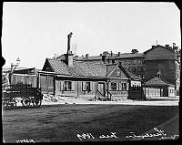 Pärlstickaregränd 10. Huset låg mitt i det som i dag är korsningen mellan Rådmansgatan och Tulegatan. Huset revs och gatan försvann 1904. Vagnen är troligen lastad med mineralvatten.