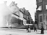 Kammakargatan österut från Upplandsgatan. Det låga hörnhuset i trä t.v. revs 1899 och ersattes av Sankt Peters kyrka.