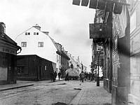 Stora Badstugatan norrut vid korsningen med Rådmansgatan. T. v. kv. Stormkransen och Sjökalven, som revs för att ge plats åt Sveavägen. Hölasset är troligen på väg till gården på St. Badstugatan 31.