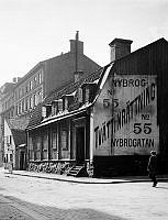 Nybrogatan söderut från Östermalmsgatan. Nybrogatan 55 (nu 75), Hellerströmska tvättinrättningen. En pojke går förbi skylten på gaveln.