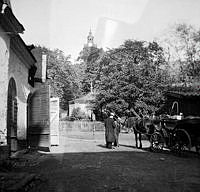 Gårdssidan vid Hantverkargatan 9. Två män står vid ett hästfordon. I fonden ses tornet på Kungsholms kyrka. Fastigheten ägdes av Nya Murbruksfabriken AB. Då kv. Bryggaren, nu kv. Munklägret.