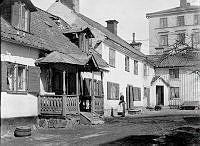 Gården till Brännkyrkagatan 139 A och B. En kvinna står bredvid verandan. Tidigare kv. Drakenberg. Nu Hornsbruksgatan 1, kv. Spettet.