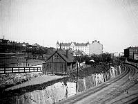 Utsikt från Rosenlundsgatans bro över järnvägen österut. Centralt i bild ett litet trähus vid Fatbursgatan 3 i kvarteret Dykärret. I fonden Timmermansgatan 39-43 byggt 1906 i kvarteret Dykärret.