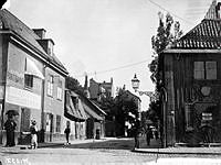 Torkel Knutssonsgatan 29-31 söderut från Hornsgatan. Huset t.h. ligger vid Hornsgatan 51 och står här inför rivning. T.v. går en kvinna med paraply. Pantbank står det på husväggen.