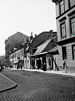 Sankt Paulsgatan västerut från Bellmansgatan. Sankt Paulsgatan 20-24 med skyltar på butiksfasaderna.