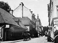 Södermannagatan norrut från Kocksgatan med Katarina kyrka i fonden. T.v. finns en speceriaffär vid Södermannagatan 10.